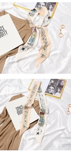 Detail of elegant floral silk scarf with French bow design on soft white satin background