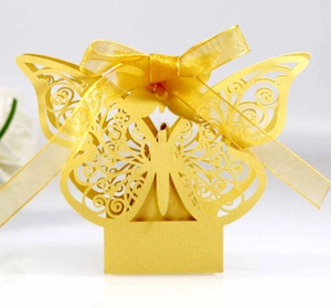 Macro shot of gold laser-cut butterfly favor box with elegant pearl paper texture