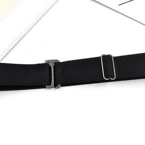 Close-up of black elastic kids belt with metal buckle and adjustable slider on white background