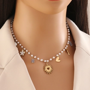 Collier de perles fantaisie avec pendentifs cœur dorés et perles bleues sur un mannequin