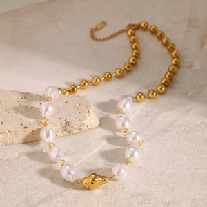 Close-up of gold beaded necklace with irregular white pearls and large center bead