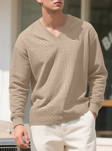 Detailed close-up of khaki jacquard knit sweater showing premium geometric texture and V-neck