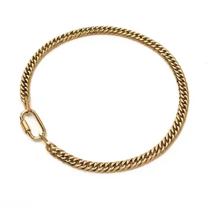Polished gold curb chain detail featuring a stylish industrial carabiner clasp closure