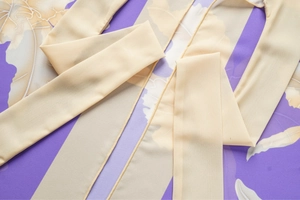 Vista dettagliata del tessuto chiffon a fiori viola con volant sulle spalline