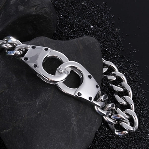 Macro detail of silver hip hop bracelet with iced-out handcuff clasp and cuban chain