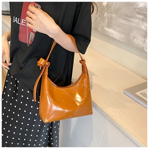 Détail du sac à épaule orange vif en cuir PU avec clous matelassés et sangle nouée