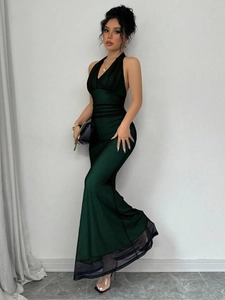 Detail of dark green satin evening gown with halter neck and mesh fishtail hemline