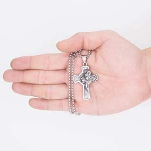 Retro stainless steel lion head cross pendant necklace held by a hand on white background