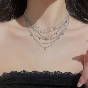 Close-up of elegant multi-layer silver beaded necklace with zircon stones on female neck