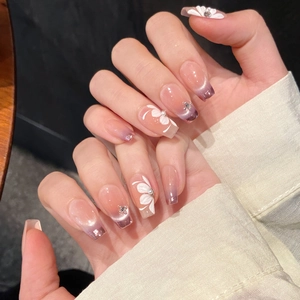 Violet cat eye press-on nails with 3D white flower design and small rhinestones