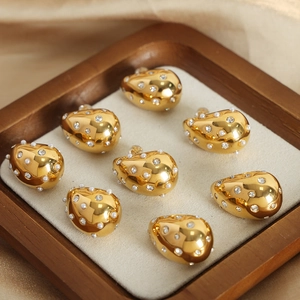 Elegant gold teardrop earrings with inlaid pearls and zircon on silk fabric display