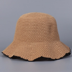 Close-up of knit sun hat featuring a wavy black scalloped edge and woven texture