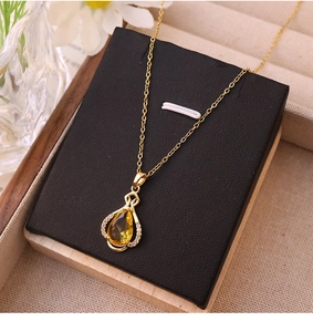 Detail of yellow teardrop zircon perfume bottle pendant necklace in gold-plated steel