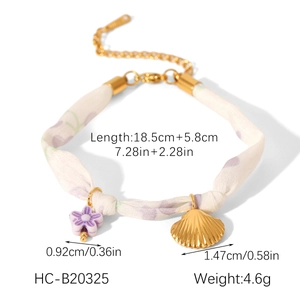 Detailed view of bohemian silk fabric bracelet with lavender floral print and shell charm
