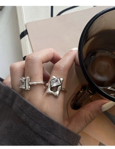 Detail of 925 silver rings with rectangle crystals and lava texture on model fingers