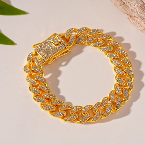 Detail of gold Cuban link bracelet with sparkling rhinestones on a minimalist background