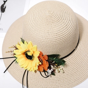 Close-up of woven sun hat featuring a vibrant sunflower and orange floral decoration