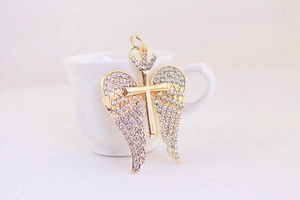 Close-up of golden crystal crown angel wings pendant with rhinestone details