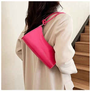 Detail of vibrant magenta baguette bag with glossy finish and unique knotted shoulder strap