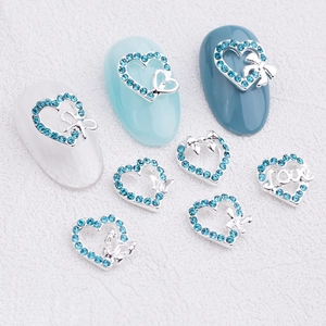Hollow heart nail charms with light blue rhinestones, bows, and butterfly accents