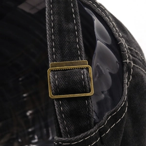 Detail der verstellbaren Metallschnalle und Kontrastnähte der gewaschenen Denim-Kappe