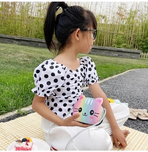 Detail of cute rainbow glitter cat crossbody bag on a little girl outdoors