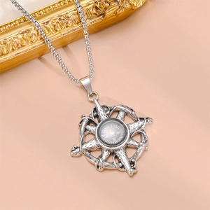 Detail view of retro silver nautical compass pendant with helm design and steel chain