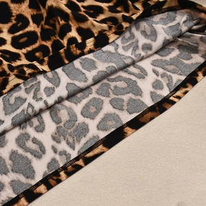 Makroaufnahme von Stoff mit Leopardenmuster zeigt detaillierte Nähte und Textiltextur
