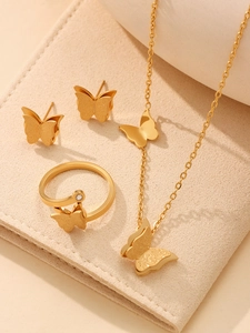 Detailed view of golden butterfly jewelry set featuring a necklace, ring and earrings on padding