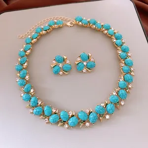 Vintage turquoise jewelry set with gold necklace and stud earrings featuring clear crystals