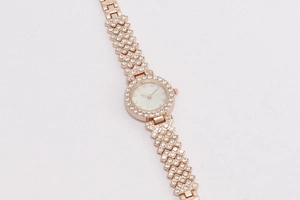 Macro detail of rose gold jewelry watch with shell dial and sparkling rhinestones