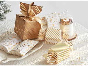 Close-up of elegant gold-stamped Christmas gift boxes with festive ribbons and patterns