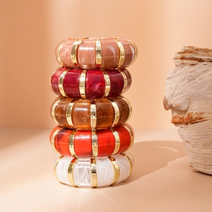 Detailed stack of five acrylic geometric resin bangles with gold metal separators