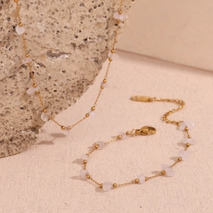 Detail of 18K gold-plated necklace and bracelet set featuring natural pink crystal stones