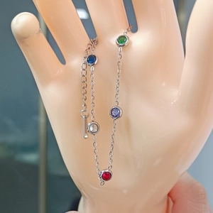 Titanium steel bracelet with colorful round gems and a small key charm on a silver chain
