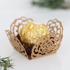 Détail macro d'un plateau décoratif pour chocolat évidé au laser motif rose doré brillant