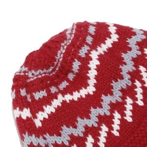 Close-up of thick knit material featuring red, white, and gray bohemian wave patterns