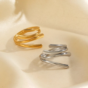 Chunky 18K gold and silver plated stainless steel spiral rings on beige silk fabric