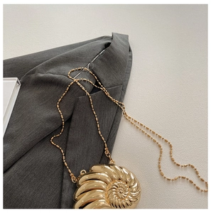 Detail der goldenen abendtasche in schneckenform mit feiner spiralstruktur
