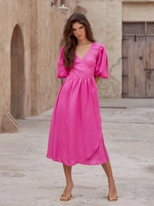 Detail eines V-Ausschnitt-Wickelkleids in Magenta aus Baumwolle mit Puffärmeln