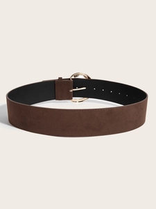 Gros plan d'une ceinture large marron vintage avec une boucle ronde dorée et un fini texturé