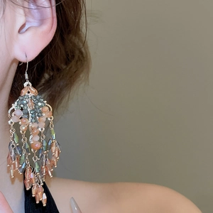Detail of vintage bohemian tiered crystal fringe drop earrings worn by a model
