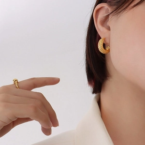 Detailed view of textured 18k gold plated C-shaped earrings and matching ring set