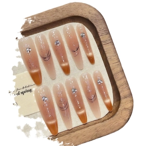 Brown ombre press-on nails with silver glitter, black swirls and 3D bow accents
