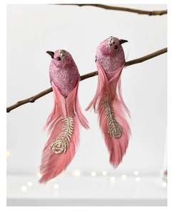 Close-up of pink artificial glitter birds with feathers on a branch for Christmas decor