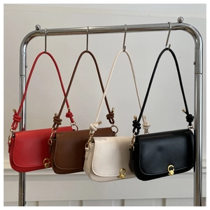Detailansicht von vier minimalistischen Satteltaschen in verschiedenen Farben am Ständer