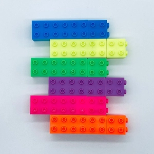 Close-up of stackable plastic building blocks in six vibrant colors on white background