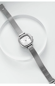 Macro detail of minimalist silver square quartz watch with sleek Milanese mesh strap
