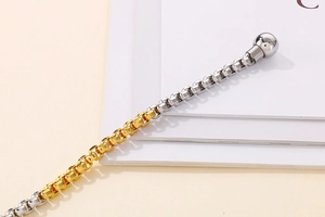 Macro shot of two-tone stainless steel box chain with polished magnetic clasp detail