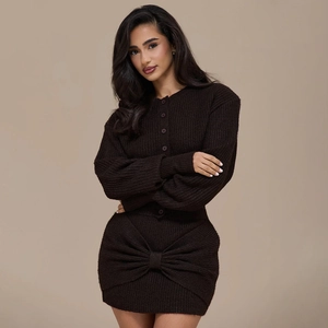 Detail of dark brown knit cardigan and skirt set featuring a large decorative bow